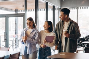 happy-diverse-students-walking-talking-university-hallway