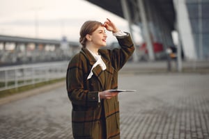 woman-brown-coat-standing-by-airport